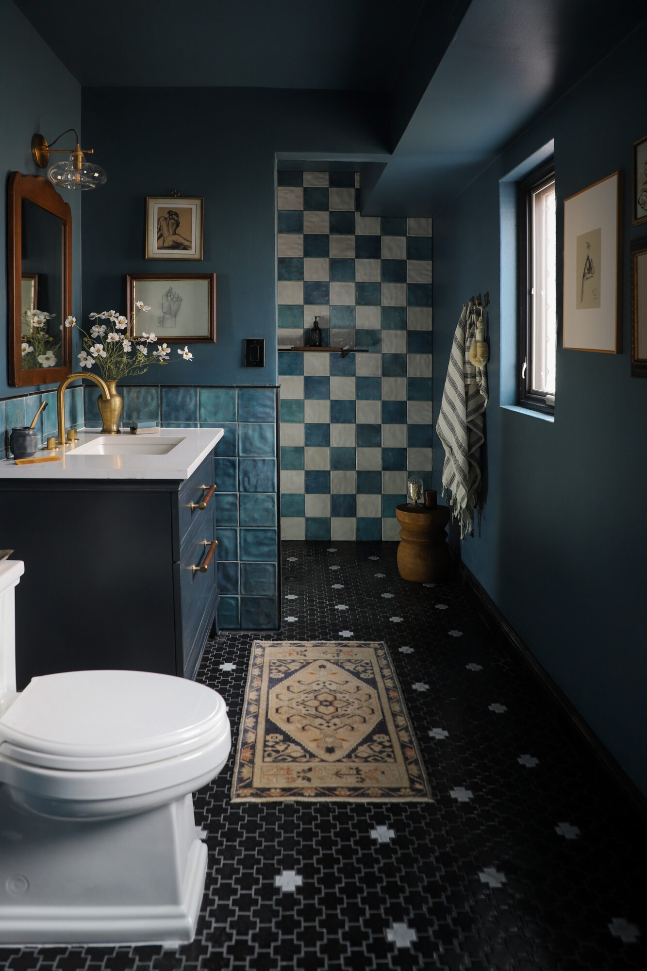 Bathroom with walk in shower with lots of creative tile patterns on the floor and shower wall. Lots of warm blue tones.